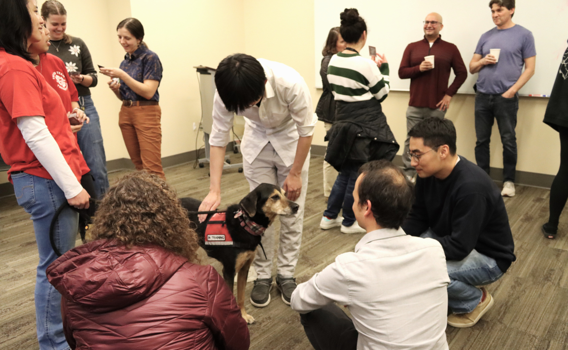 Therapy dog Charma enjoys pets during her visit to JILA