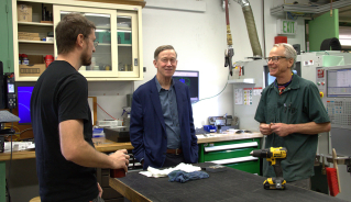 Senator Hickenlooper (center) talks to JILA's instrument shop head Kyle Thatcher (left) and JILA instrument maker Hans Green (right).