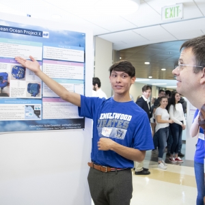 Dylan Carpenter, a student at Englewood High School, presents his group’s ocean clean up project to Dr. Eric Cornell.