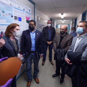 Top: From left to right, physicist Margaret Murnane, Rep. Joe Neguse, Chancellor Philip DiStefano and CU President Todd Saliman in Murnane's lab at JILA; bottom: Murnane discusses the promise of new microscope technologies during the JILA tour. (Credits: Glenn Asakawa/CU Boulder)