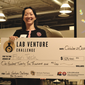 Flari Tech CEO Dr. Eva Yao stands with a check from the Lab Venture Challenge