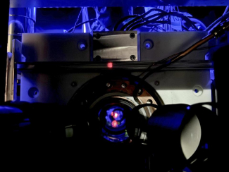 A look inside the optical atomic clock cavity, with the red light being a reflection of the laser light used in the optical lattice 