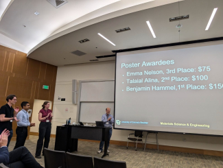 JILA graduate student Emma Nelson (left, wearing red) claps as the award winners are announced at the CU Boulder Innovation in Materials Symposium 2024