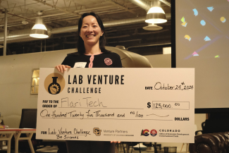 Flari Tech CEO Dr. Eva Yao stands with a check from the Lab Venture Challenge