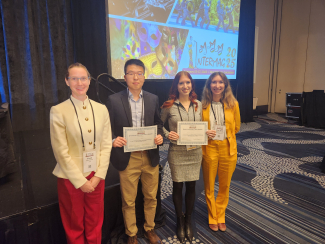 JILA graduate student Anya Grafov (second to the right) holds up her award for Best Lightning Talk