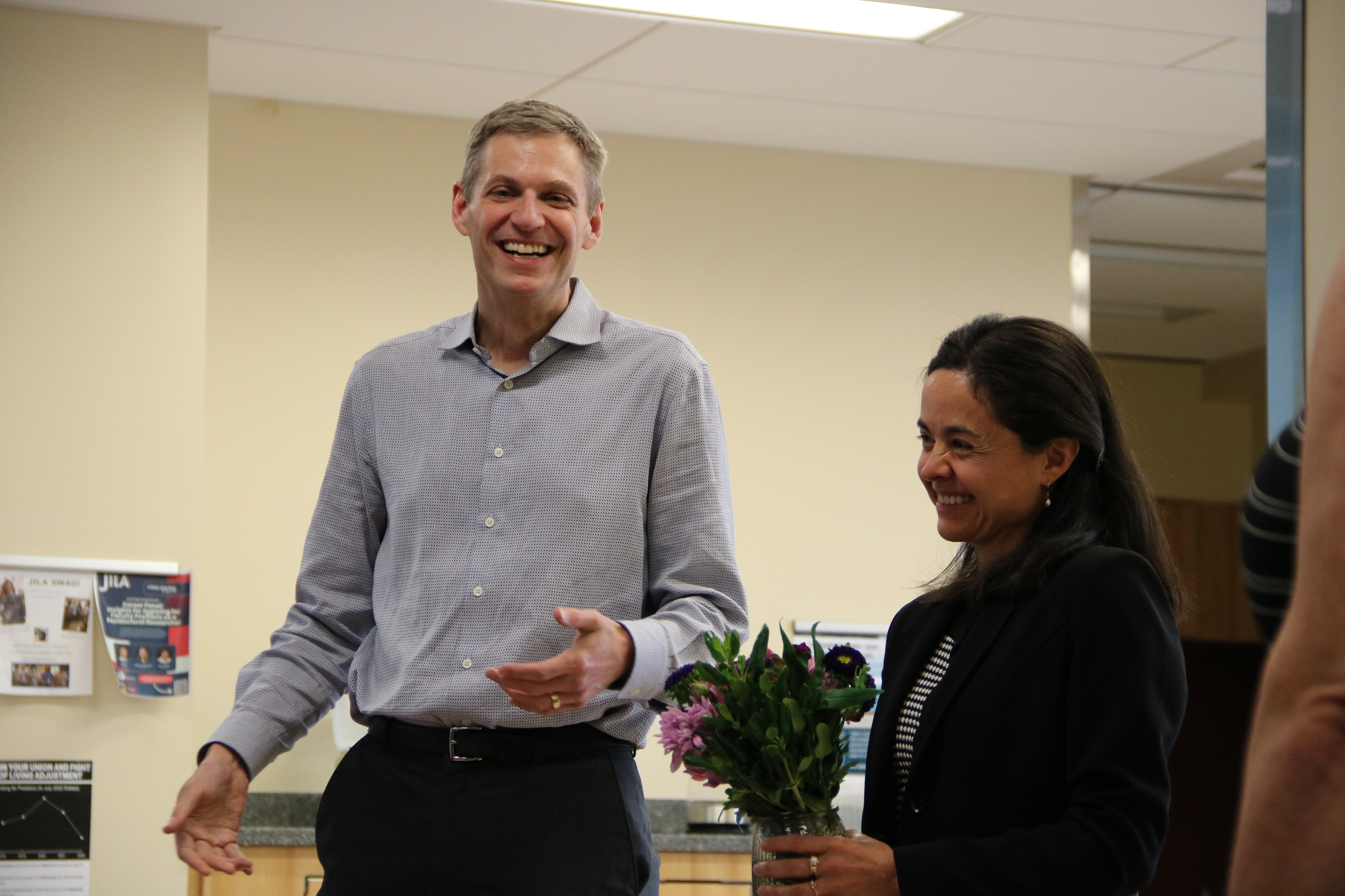 Ana Maria Rey is congratulated by JILA Fellow Chair and NIST Fellow Konrad Lehnert as Rey receives flowers in celebration of her NAS membership