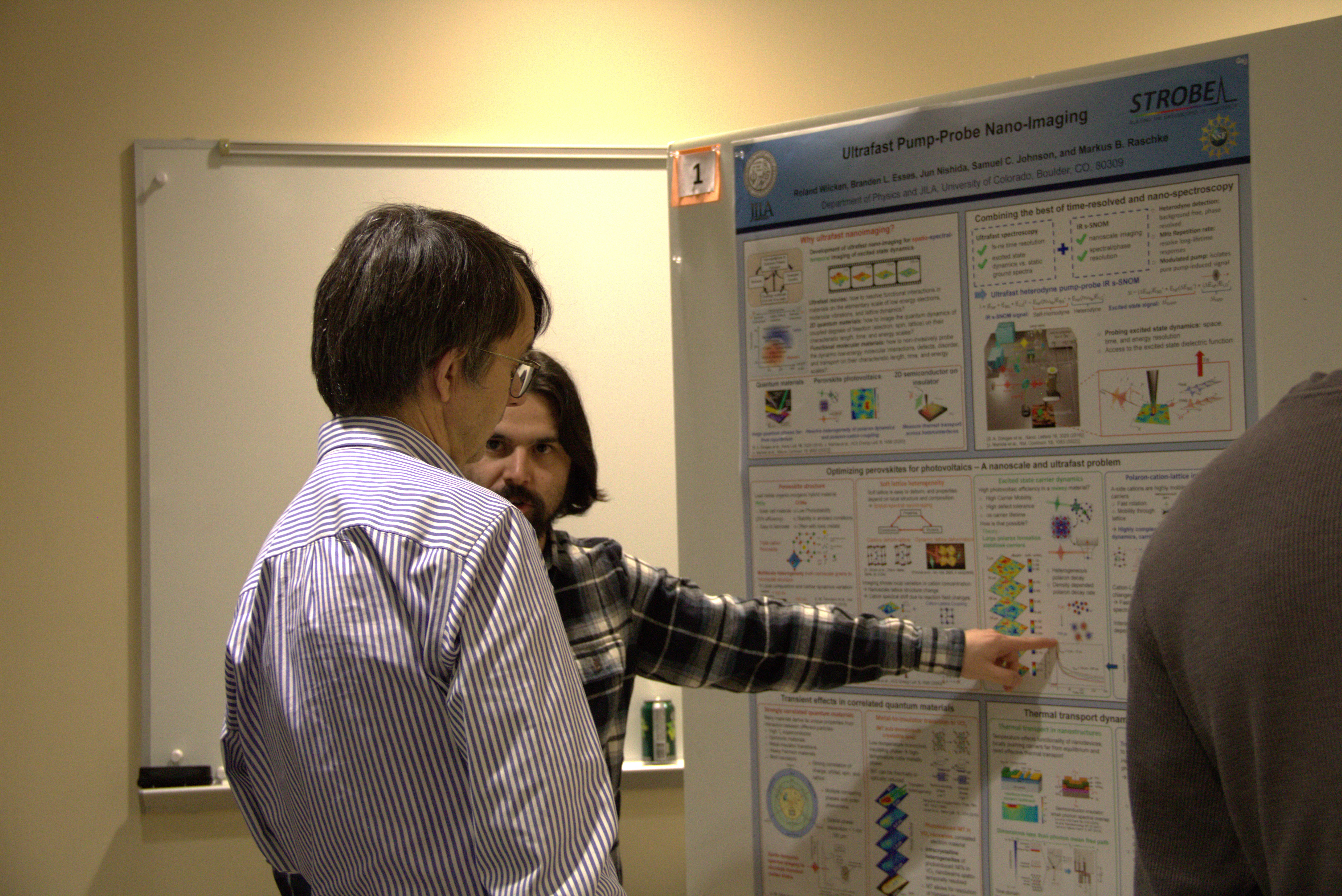 JILA and NIST Fellow Eric Cornell listens to JILA graduate student Branden Esses explain a current research project.