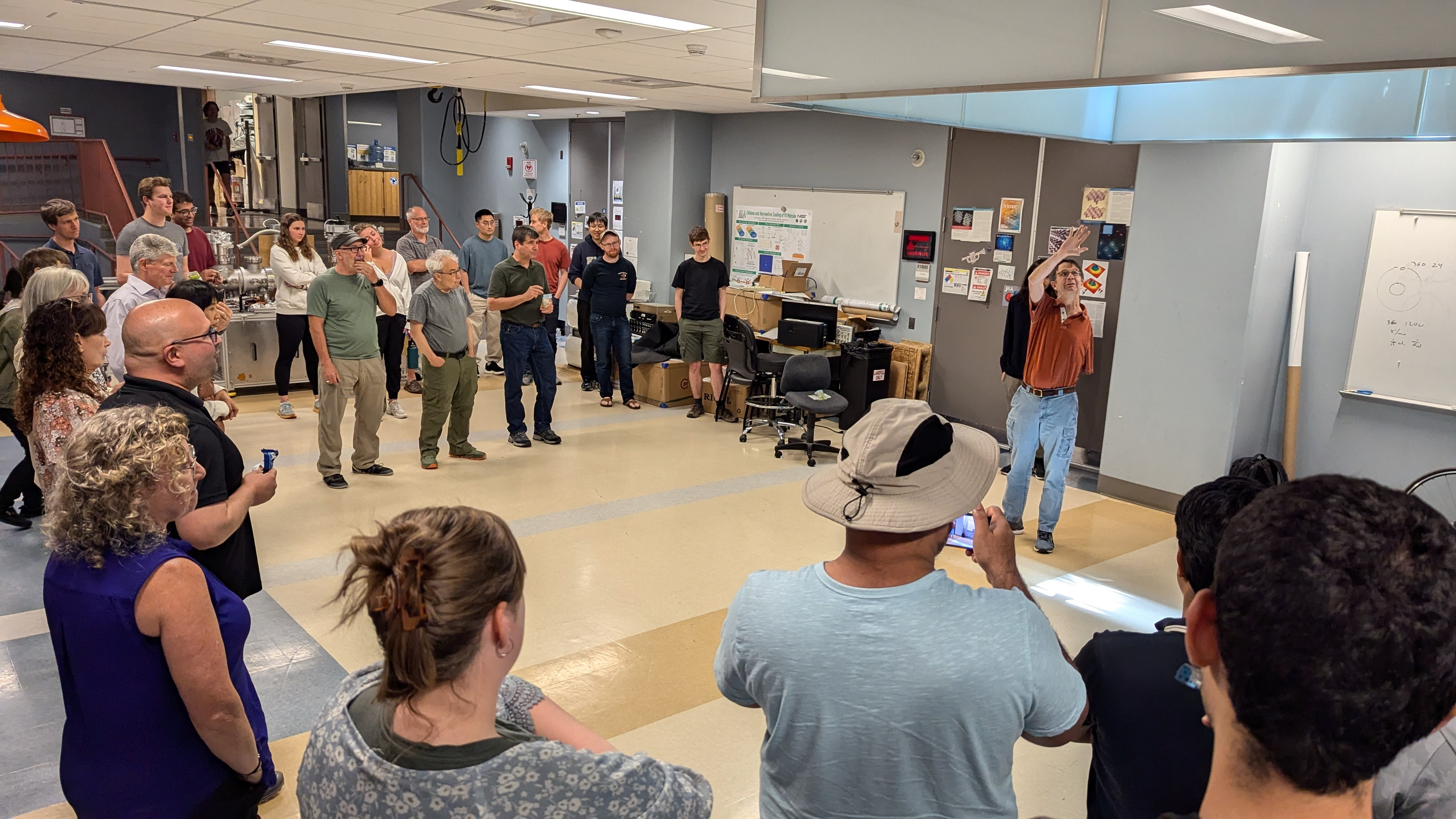 Onlookers watch as JILA and NIST Fellow and CU Boulder Physics professor Eric Cornell explains his experiment