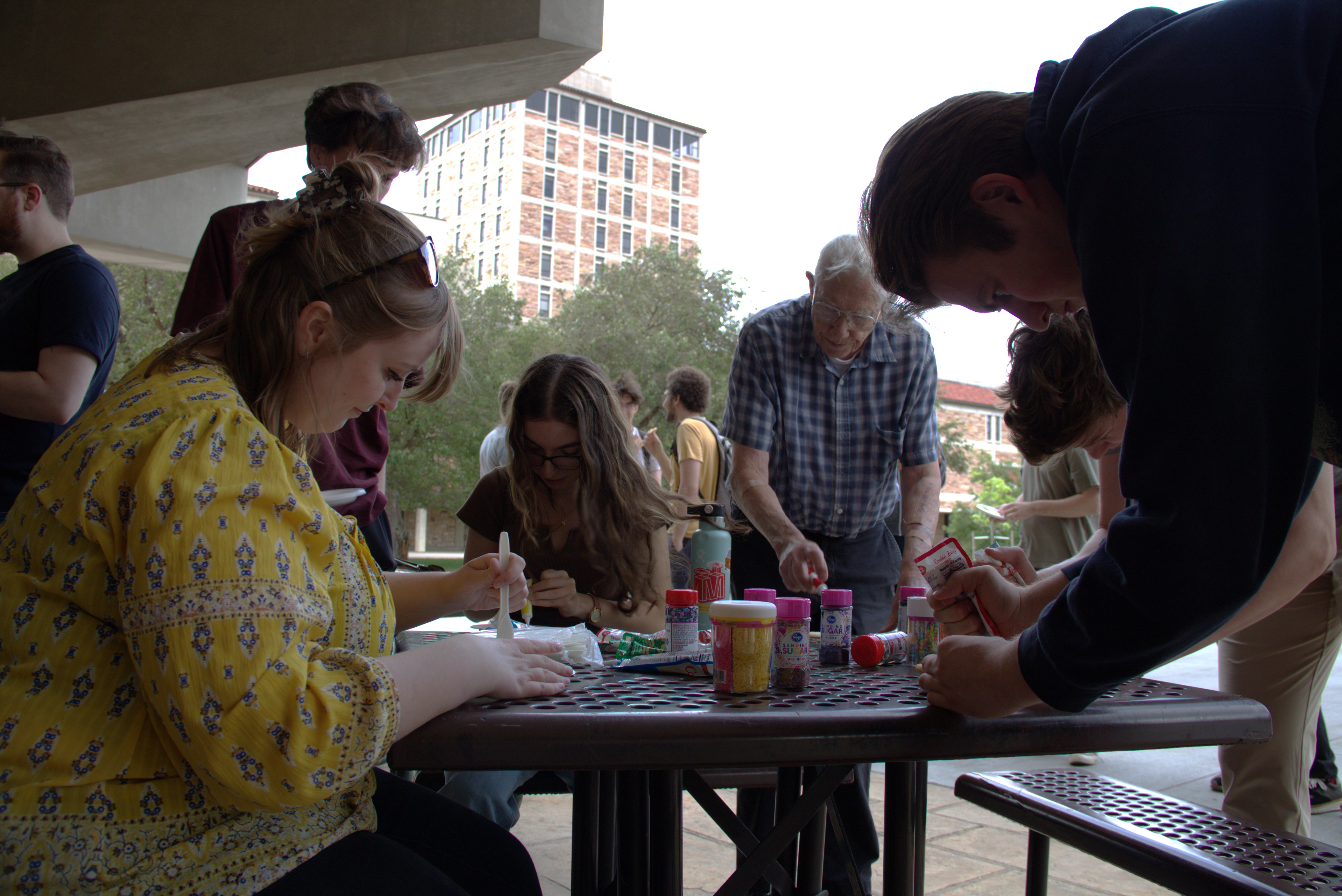 JILA staff member Hannah Douglas (left) and JILA Fellow Judah Levine (back) decorate cookies as part of JILA's Sugar Cookie Day