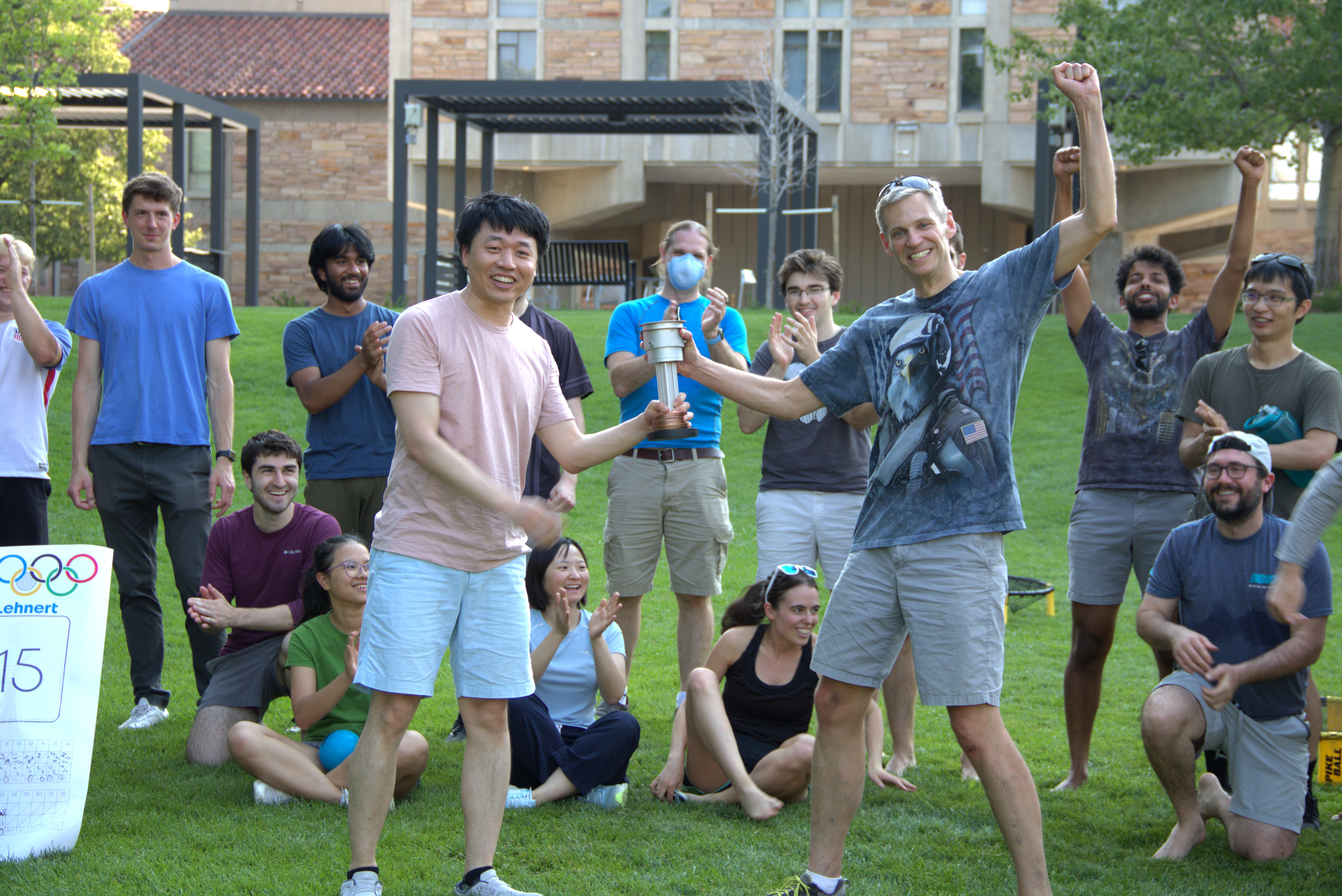 JILA Associate Fellow and University of Colorado Boulder Assistant Professor of Physics Shuo Sun hands the JILA cup to JILA and NIST Fellow and University of Colorado Boulder Physics professor Konrad Lehnert