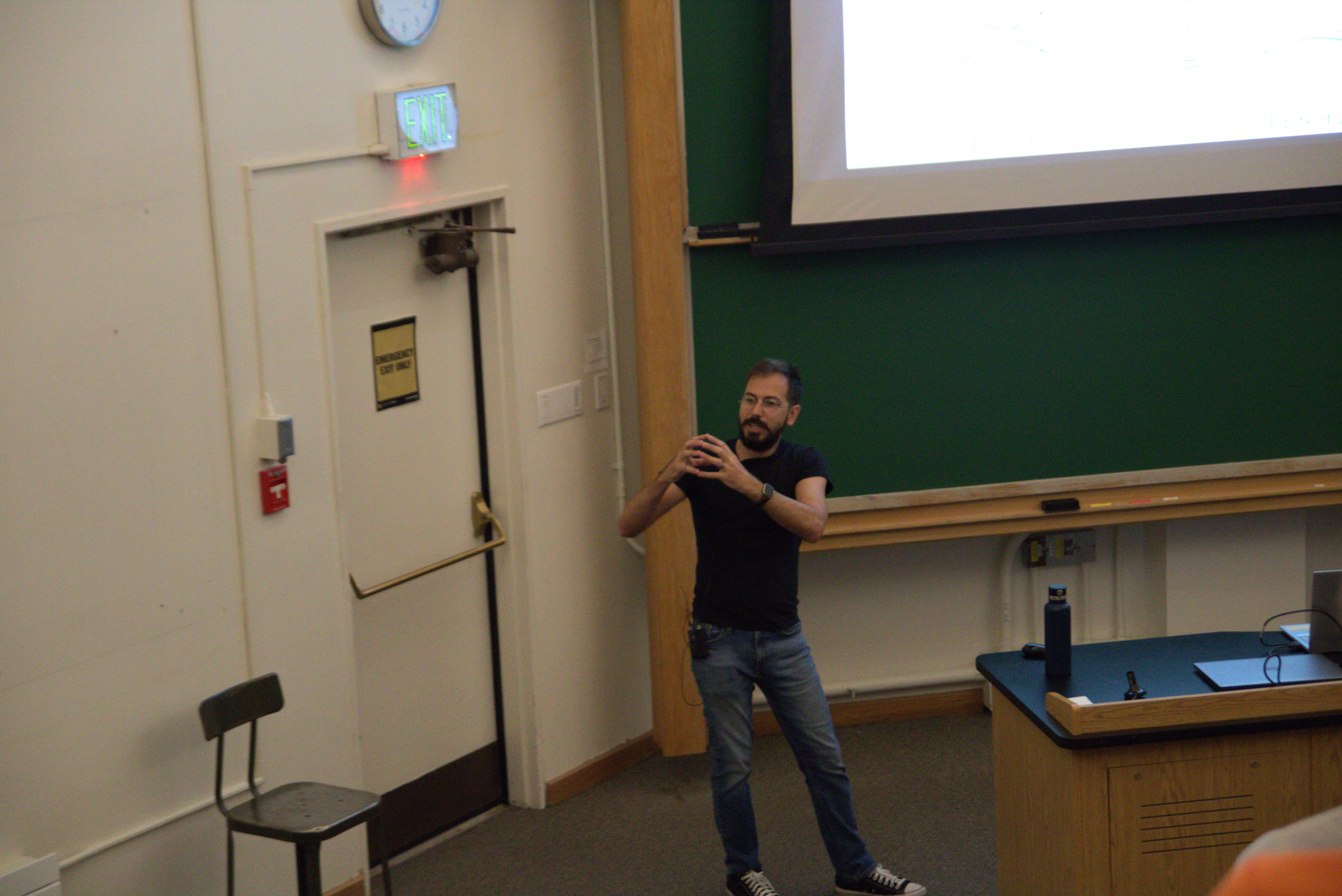 JILA graduate student Bejan Ghomashi (of the Becker group) explains a physics phenomenon during his talk